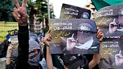 يظهر أحد المتظاهرين الفلسطينيين إشارة النصر، بينما يحمل آخرون صورًا لأبو عبيدة، المتحدث باسم كتائب القسام،بالقرب من السفارة المصرية في بيروت، لبنان، يوم السبت، 18 نوفمبر 2023.
