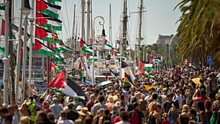 People crowd the dock ahead of the launch of a civilian flotilla bound for Gaza, in Barcelona, Spain, Sunday, Aug. 31, 2025. 