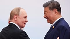 Russian President Vladimir Putin talks with Chinese President Xi Jinping during a family photo session at the SCO summit in Tianjin, 1 September 2025