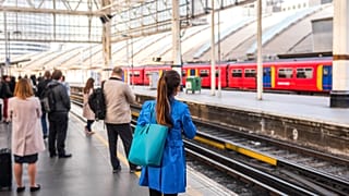 Commuters waiting at a train station for a delayed train during rush hour