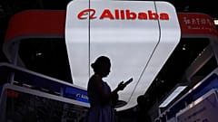 Un visitatore cammina davanti allo stand di Alibaba durante la terza edizione del China International Supply Chain Expo a Pechino, in Cina