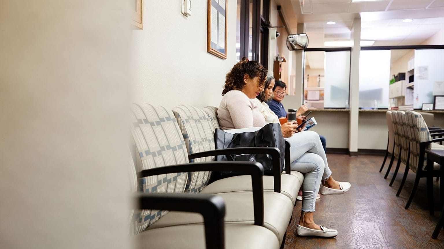 Patients sit in a doctor's office waiting room.