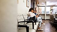 Patients sit in a doctor's office waiting room.