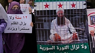 امرأة تحمل لافتة باللغة العربية كتب عليها "12 عاما والظلم لا يزال مستمرا ومتزايدا" خلال احتجاج خارج سجن رومية للمطالبة بالعفو العام عن أسرى الجماعات الإسلامية, 27أغسطس 2025