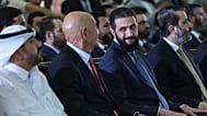 El presidente interino de Siria, Ahmed al Sharaa, mira al enviado especial a Siria, Tom Barrack, mientras asisten a la firma de un acuerdo para un consorcio energético.