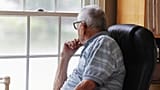 An older man looks out the window.