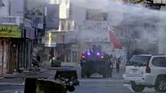 يواجه المتظاهرون المناهضون للحكومة، بعضهم يحمل أعلام البحرين، الشرطة في مركبات مدرعة في الديه، البحرين, الاثنين 20 فبراير/ شباط 2012.