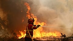 Ein Feuerwehrmann löscht am Mittwoch, den 19. September 2024, einen Brand am Rande der Stadt Sever do Vouga in Portugal, die seit mehreren Tagen von Waldbränden umgeben ist.