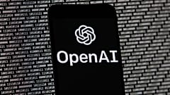 OpenAI logosu, Boston'da rastgele ikili veriler içeren bir bilgisayar ekranının önündeki bir cep telefonunda görünüyor, 9 Mart 2023.