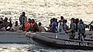 Un barco pesquero africano que transporta a 80 inmigrantes es escoltado por la Guardia Civil en su camino a la isla canaria de Tenerife, España, el 15 de agosto de 2006.