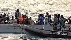 Un barco pesquero africano que transporta a 80 inmigrantes es escoltado por la Guardia Civil en su camino a la isla canaria de Tenerife, España, el 15 de agosto de 2006.
