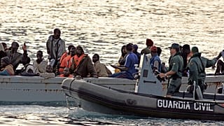 Un barco pesquero africano que transporta a 80 inmigrantes es escoltado por la Guardia Civil en su camino a la isla canaria de Tenerife, España, el 15 de agosto de 2006.
