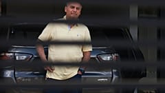 Jair Bolsonaro, atrás do portão de entrada da sua casa, onde está em prisão domiciliar, em Brasília, Brasil, quarta-feira, 3 de setembro de 2025