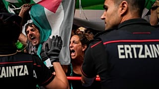 La gente sostiene banderas palestinas mientras intenta interrumpir la etapa de la carrera ciclista Vuelta a España, de Bilbao a Bilbao, España, el 3 de septiembre de 2025.