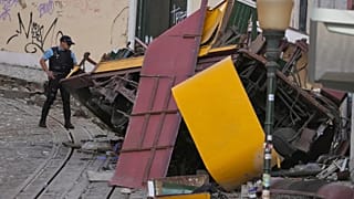Police officers inspect the site where a tourist streetcar derailed and crashed in Lisbon, 4 September, 2025