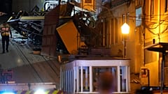 Un agente di polizia cammina sul luogo di un deragliamento di un tram elettrico a Lisbona, Portogallo