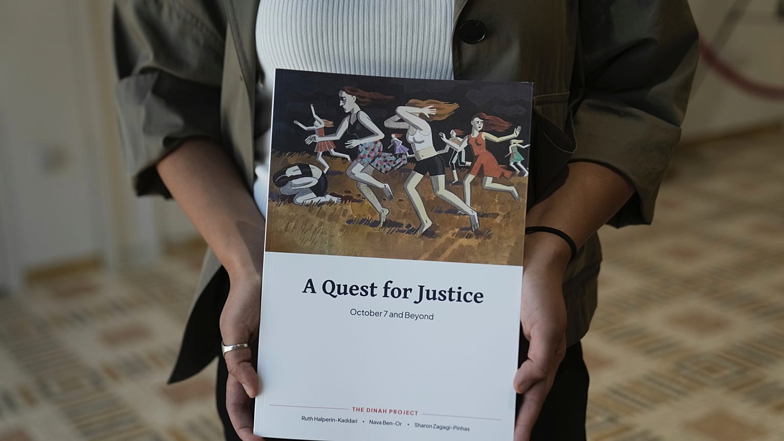 A copy of the report by the Dinah Project on sexual violence committed on Oct. 7, 2023 by Hamas is displayed by a journalist before a ceremony presenting the report