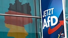 Plakat wyborczy niemieckiej skrajnie prawicowej partii Alternatywa dla Niemiec (AfD) przed gigantycznym plakatem wyborczym przedstawiającym mapę Niemiec, 29 stycznia 2025 r.