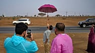 People stand in the rain as they chase rain showers at Fujairah, United Arab Emirates.