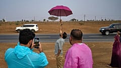 Personas de pie bajo la lluvia mientras persiguen los chubascos en Fujairah, Emiratos Árabes Unidos.