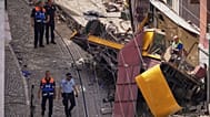 Police officers inspect the site where a tourist streetcar derailed and crashed in Lisbon, Portugal, Thursday, Sept. 4, 2025.