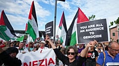متظاهرة تحمل لافتة كتب عليها "أنتم جميعًا شهود على الإبادة الجماعية" خلال مسيرة لدعم الشعب الفلسطيني في غزة، في إيطاليا، السبت 30 أغسطس 2025.