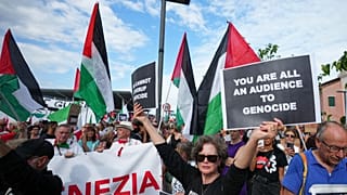 متظاهرة تحمل لافتة كتب عليها "أنتم جميعًا شهود على الإبادة الجماعية" خلال مسيرة لدعم الشعب الفلسطيني في غزة، في إيطاليا، السبت 30 أغسطس 2025.