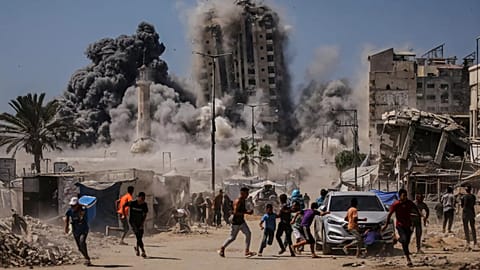 Palestinians run for cover during an Israeli airstrike on a high-rise building in Gaza City, 5 September, 2025