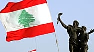 علم لبناني ضخم بجانب تمثال الشهداء المتضرر من الحرب الأهلية في وسط بيروت، لبنان،