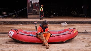 Un bombero espera sentado en una lancha para entrar en el aparcamiento subterráneo inundado del centro comercial MN4, el lunes 4 de noviembre de 2024.