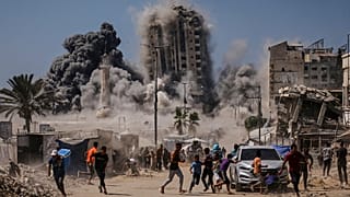 فلسطينيون يركضون للاحتماء خلال غارة جوية إسرائيلية على مبنى شاهق في مدينة غزة, الجمعة, سبتمبر. 5 يناير 2025 ، بعد أن أصدر الجيش الإسرائيلي تحذيرا مسبقا