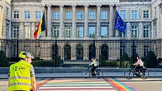 Ludzie przejeżdżają obok belgijskiego parlamentu w Brukseli, Belgia, wtorek, 2 września 2025 r. 