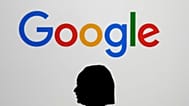 امرأة تمشي على شاشة عملاقة تحمل شعارا في حدث في مختبر جوجل في باريس على هامش قمة عمل الذكاء الاصطناعي في باريس, في فبراير. 9, 2025