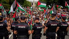 أشخاص يحملون الأعلام الفلسطينية يجلسون في الشارع بعد تعطيل المرحلة الحادية عشرة من سباق فويلتا الإسباني للدراجات في بلباو 3 سبتمبر 2025