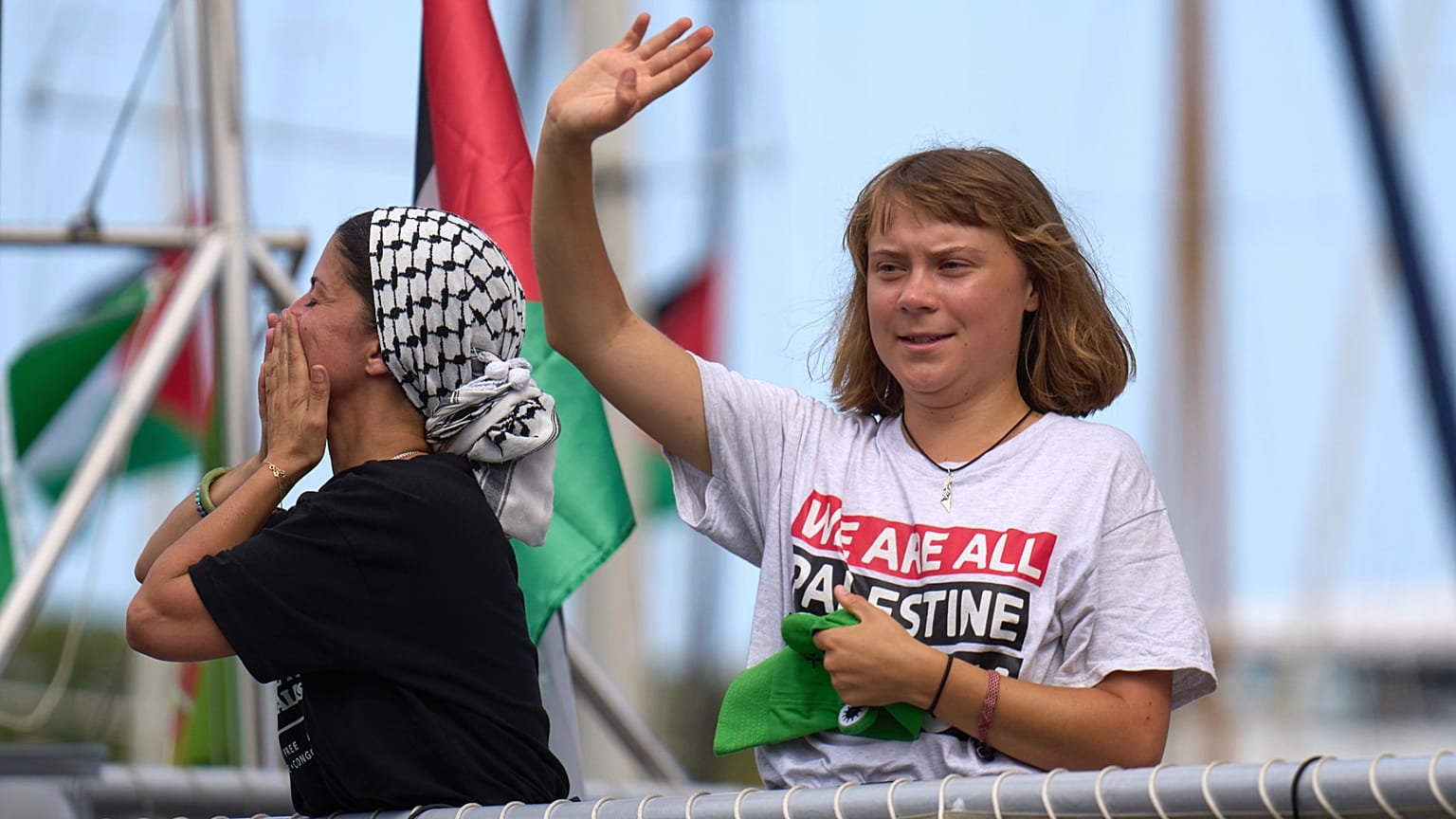 الناشطة المناخية السويدية غريتا ثونبرغ تلوح من قارب يشارك في أسطول مدني متجه إلى غزة، بهدف كسر الحصار الإسرائيلي في برشلونة، إسبانيا، الأحد 31 أغسطس/ آب 2025.