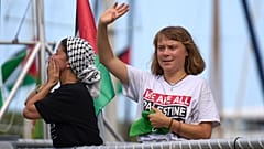 الناشطة المناخية السويدية غريتا ثونبرغ تلوح من قارب يشارك في أسطول مدني متجه إلى غزة، بهدف كسر الحصار الإسرائيلي في برشلونة، إسبانيا، الأحد 31 أغسطس/ آب 2025.