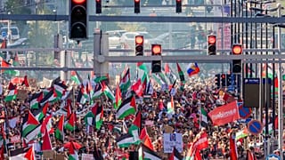 Persone sventolano bandiere palestinesi durante una manifestazione nel centro di Bruxelles, domenica 7 settembre 2025.