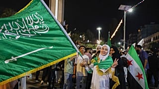 فتاة تحمل العلم السعودي احتفالا بإعلان الرئيس الأمريكي دونالد ترامب عن خطط خلال زيارته إلى المملكة العربية السعودية لتخفيف العقوبات على سوريا، الثلاثاء 13 مايو/ أيار 2025.