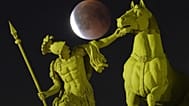 Der Vollmond geht während der totalen Mondfinsternis hinter einer Skulptur auf dem Palastplatz in St. Petersburg auf.