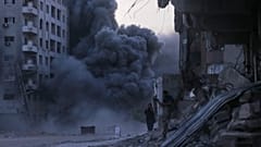الفلسطينيون يحتمون أثناء غارة إسرائيلية استهدفت مبنى في مدينة غزة، الأحد 7 أيلول/سبتمبر 2025. 