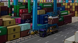 A crane loads a shipping container into a truck at an automated container port in Tianjin, China.