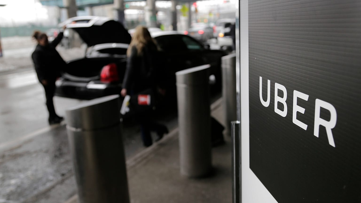 FILE - Dans cette photo d'archive du 15 mars 2017, un panneau indique un point de prise en charge pour le service de voiture Uber à l'aéroport LaGuardia de New York.
