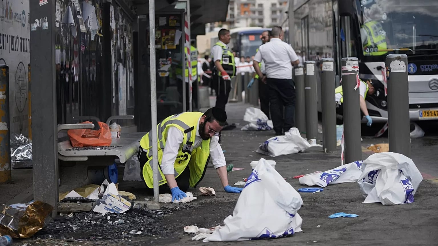 Israeli ZAKA rescue and recovery personnel clean bloodstains at the scene of a shooting attack carried out by two Palestinian gunmen in Jerusalem, 8 September, 2025