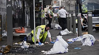 Israeli ZAKA rescue and recovery personnel clean bloodstains at the scene of a shooting attack carried out by two Palestinian gunmen in Jerusalem, 8 September, 2025