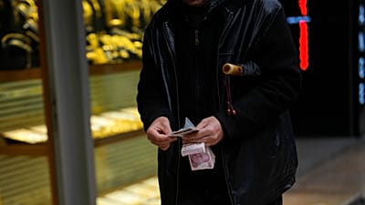 ARŞİV: İstanbul Eminönü'ndeki bir döviz bürosunun önünde para sayan bir adam / 25 Ocak 2024.