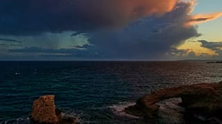 Clouds are seen over the natural rock bridge named "Love Bridge" during sunset at Ayia Napa resort in the southeast Mediterranean island of Cyprus.