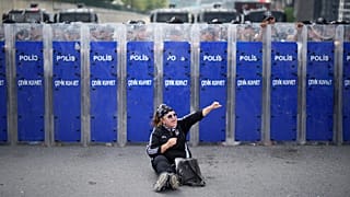 Riot police hold their shields as a supporter of Turkey's main opposition CHP shouts slogans during a demonstration outside the party's HQ in Istanbul, Monday, Sept. 8