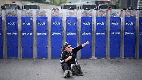 Riot police hold their shields as a supporter of Turkey's main opposition CHP shouts slogans during a demonstration outside the party's HQ in Istanbul, Monday, Sept. 8