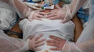 Nurses perform timed breathing exercises on a COVID-19 patient on a ventilator in the COVID-19 intensive care unit at the la Timone hospital in Marseille, 31 December, 2021