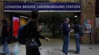 Os passageiros passam pela entrada fechada da estação de metro de London Bridge durante uma greve